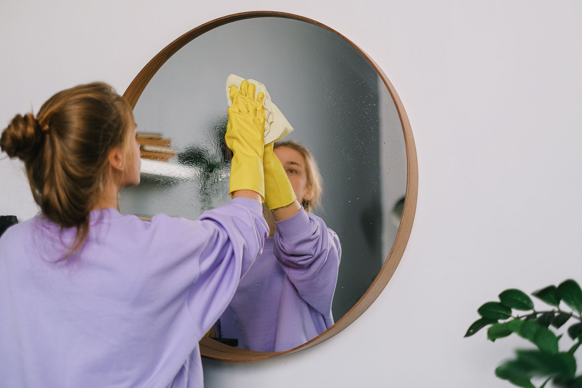 Cleaner polishing a mirror